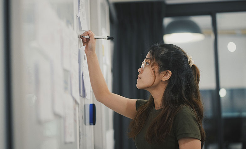 Person planning out a process on a whiteboard