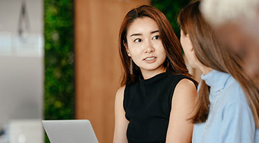 two people talking, one person taking notes